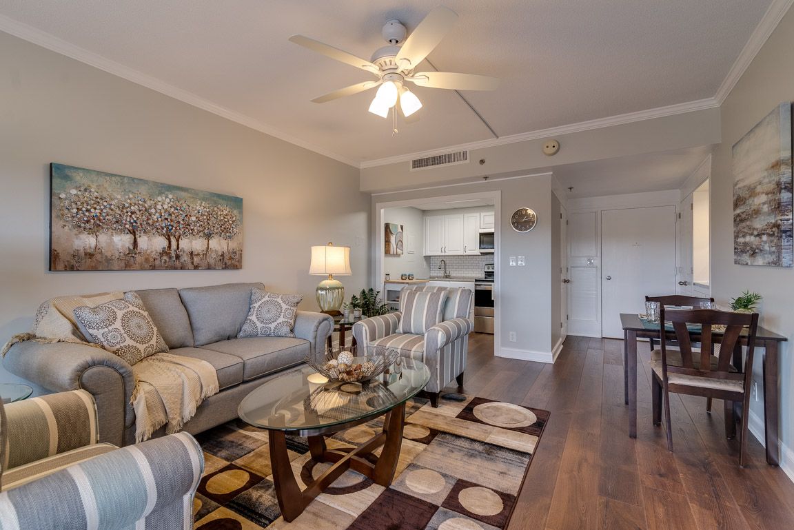 A cozy living room with modern decor, featuring a sofa, coffee table, and artwork on the wall.