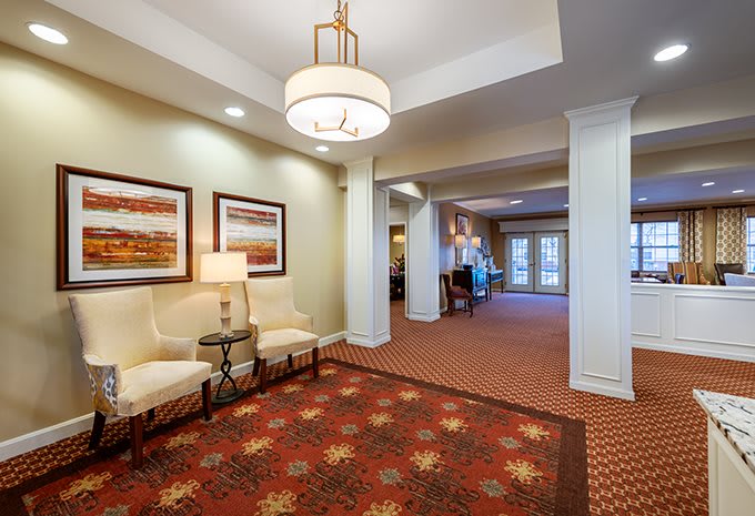 A warmly lit lobby area with comfortable seating and decorative artwork.