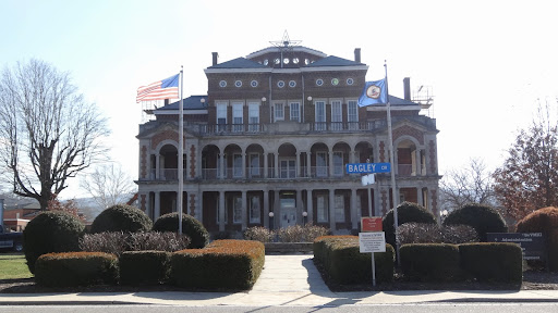 A historical government building featuring a grand architectural design and flags at the forefront.
