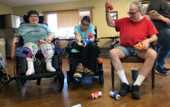 A group of elderly individuals engaging in a fun activity indoors, with some participants in wheelchairs.
