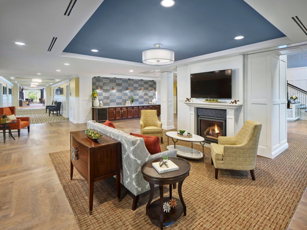 A cozy living room with modern furnishings, featuring a fireplace, television, and comfortable seating.