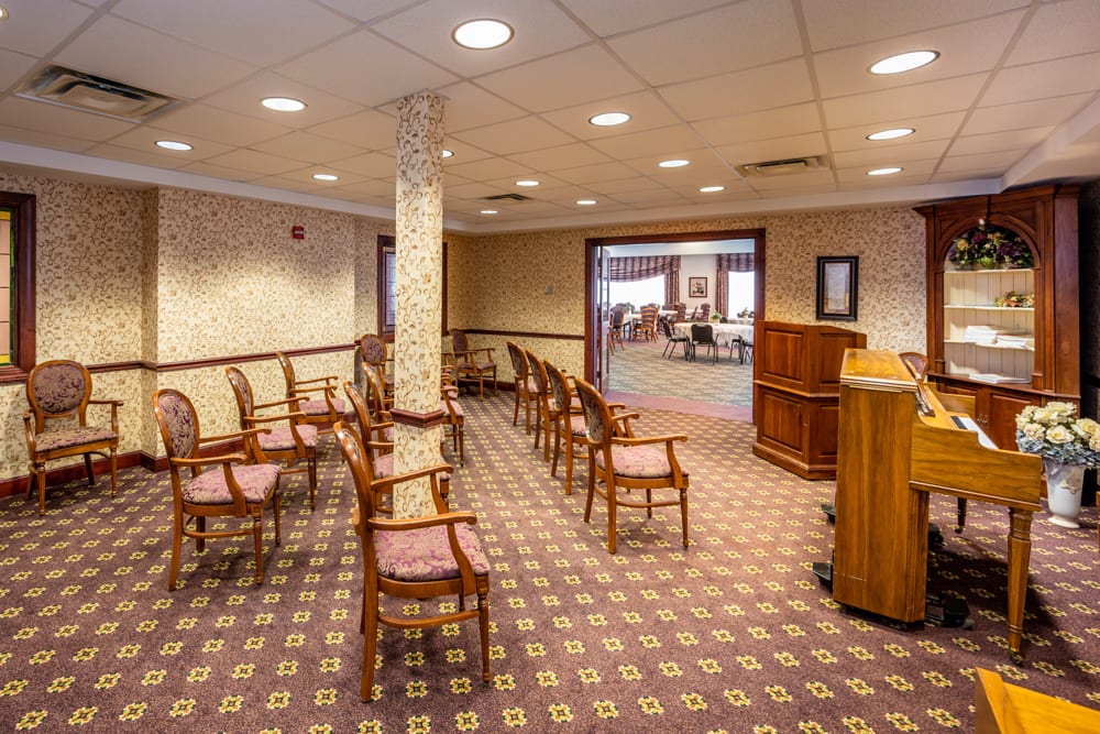An empty meeting room with arranged chairs and a podium.