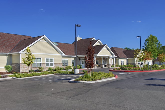 Suburban residential building with parking lot on a clear day.