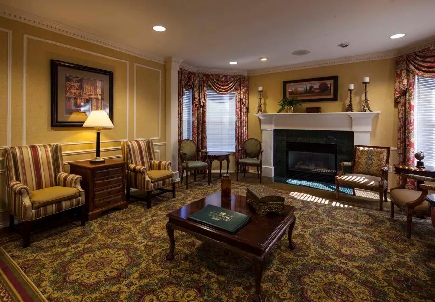 A cozy living room with traditional decor, featuring a fireplace and classic furniture.