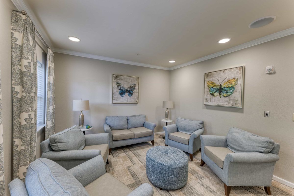 A cozy living room with comfortable seating and butterfly artwork on the walls.