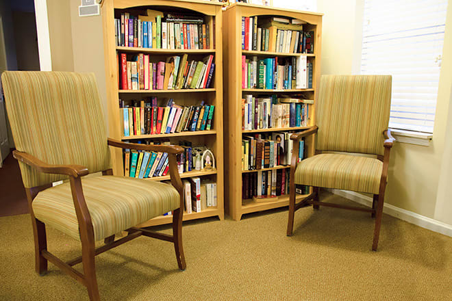 A cozy reading area with bookshelves and comfortable chairs.