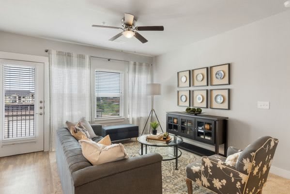 A modern living room featuring a comfortable sofa, glass coffee table, and decorative artwork on the walls.