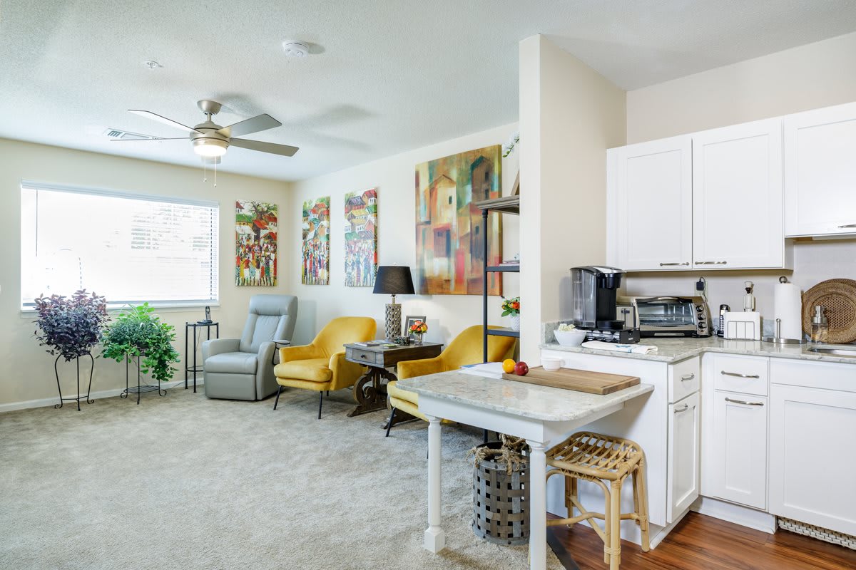 A modern living room featuring yellow chairs, diverse artwork, and cozy furnishings.