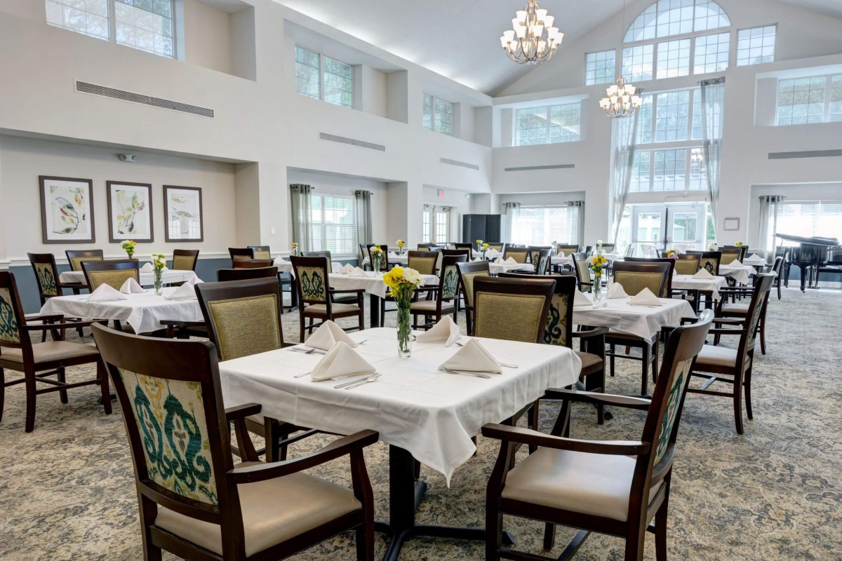 An elegant dining room with set tables and abundant natural light.