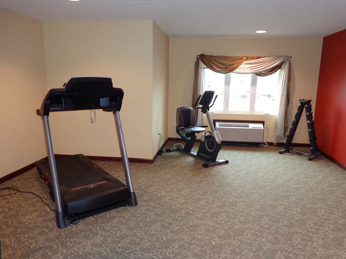 A small indoor gym with a treadmill and stationary bike.