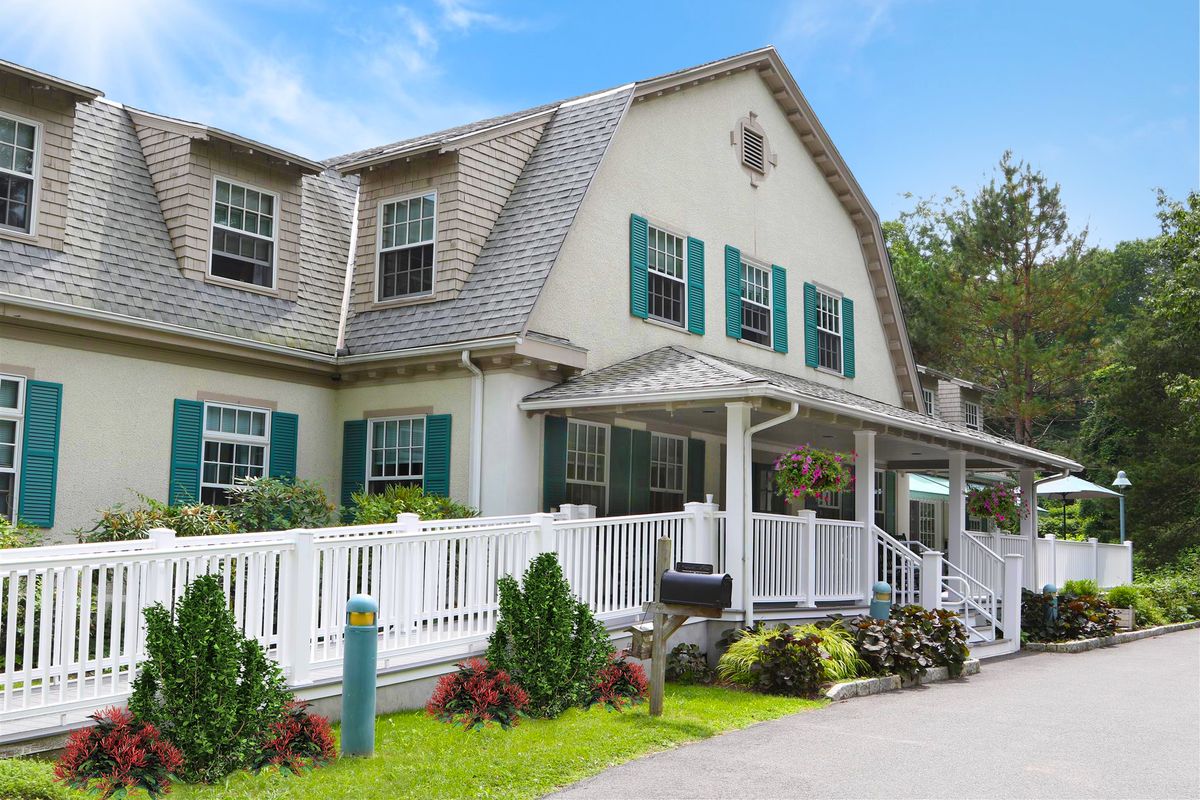 Charming residential house with a front porch and white picket fence.