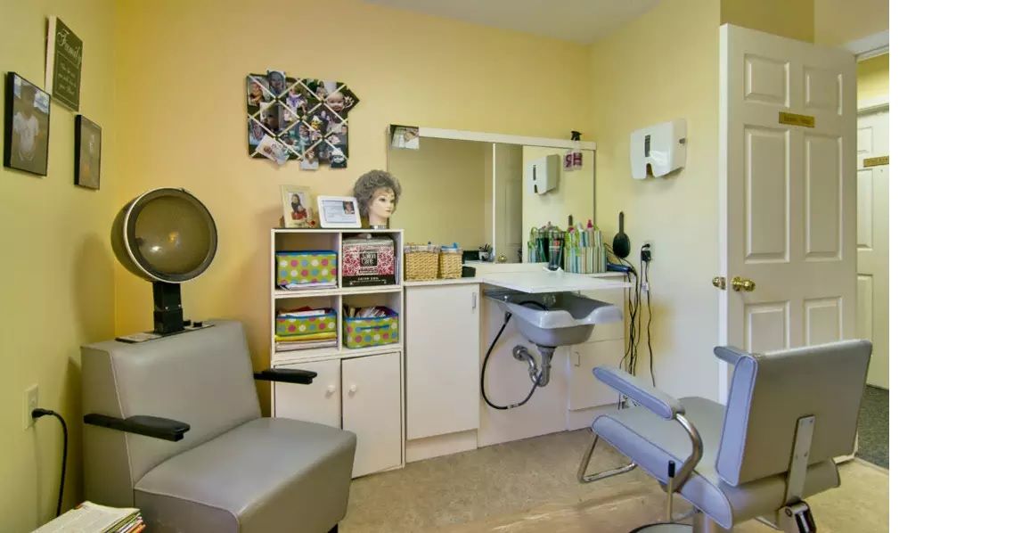 A well-equipped hair salon interior with a chair, sink, and various hair products.
