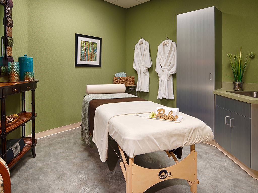 A tranquil spa room featuring a massage table and robes, designed for relaxation.