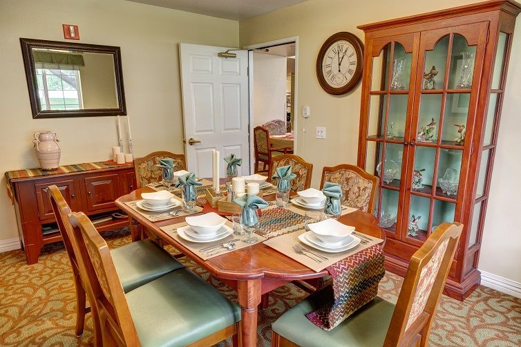 A cozy dining room with a set table for six, featuring elegant tableware and decor.