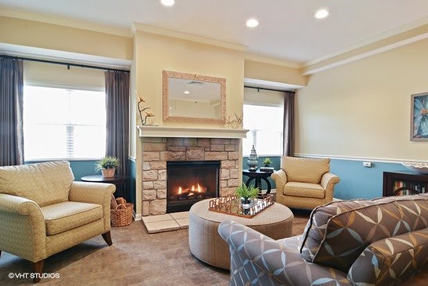 A cozy living room with a fireplace, armchairs, and a stylish coffee table.