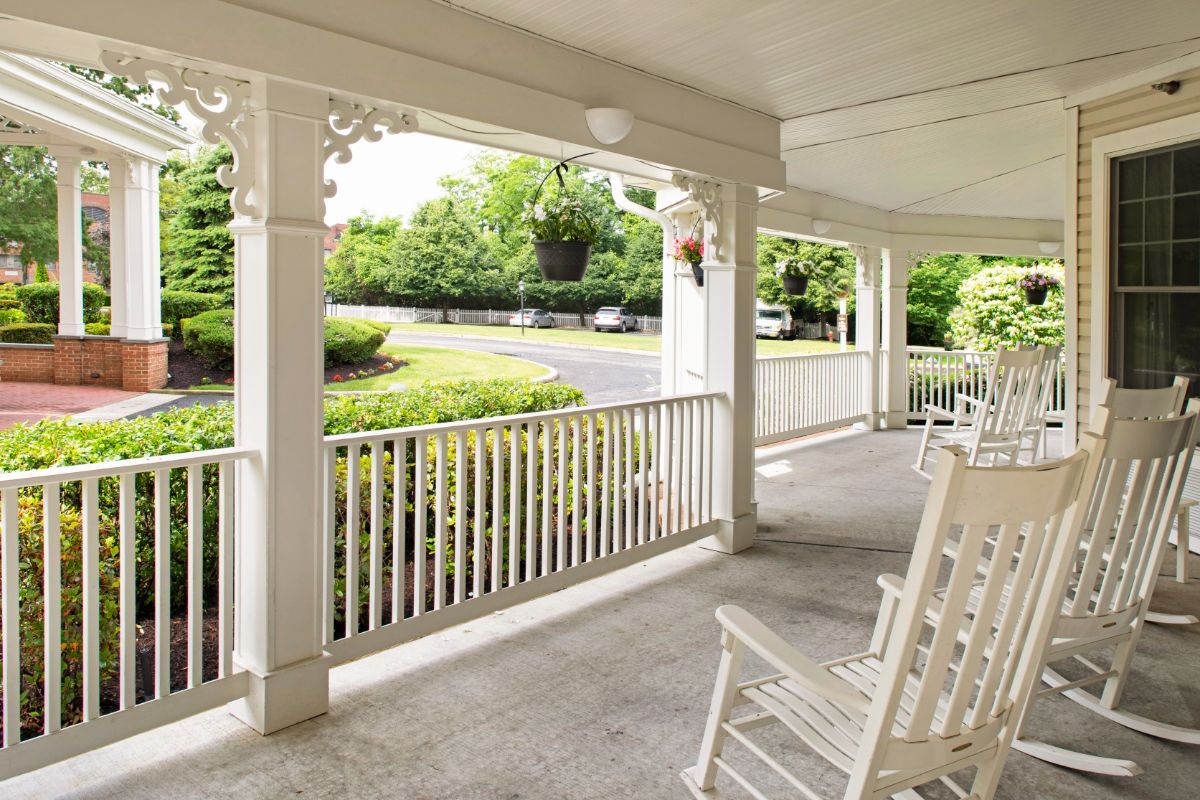 A peaceful porch with rocking chairs overlooking a garden.