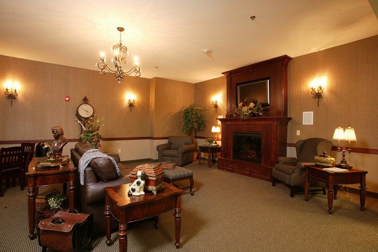 A cozy living room with a fireplace, elegant chandelier, and traditional decor.