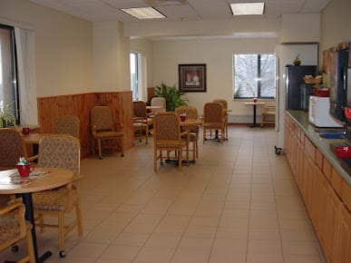 A quiet and neatly arranged waiting room with chairs and tables.