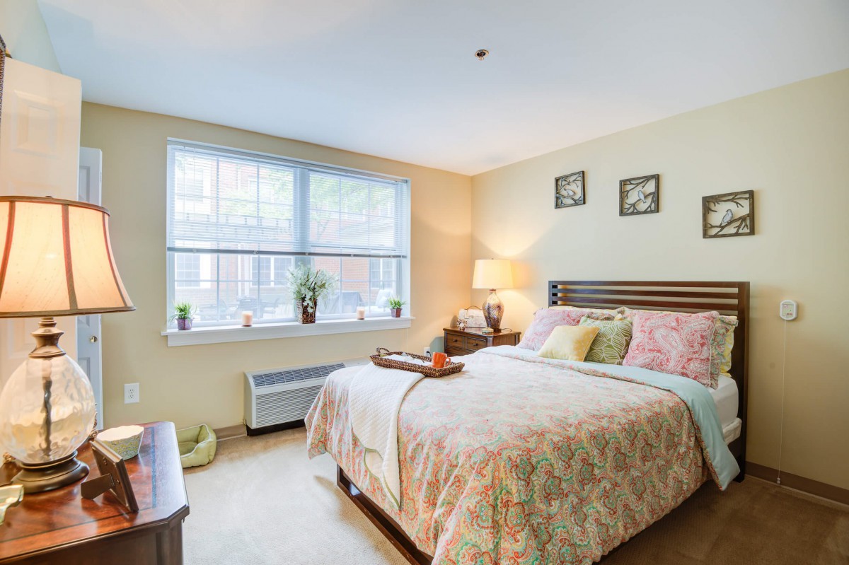A cozy bedroom interior with a neatly made bed, soft lighting, and decorative elements.