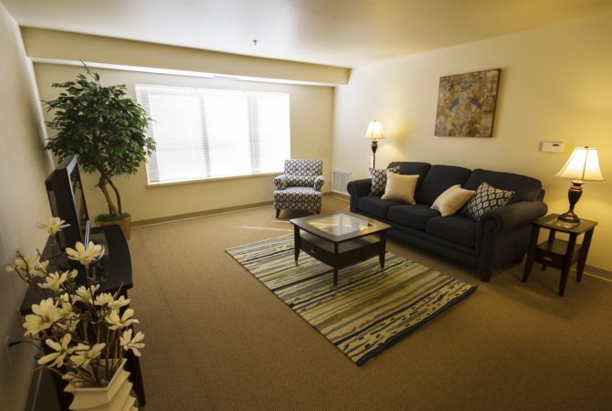 A cozy living room with a sofa, armchair, and coffee table.