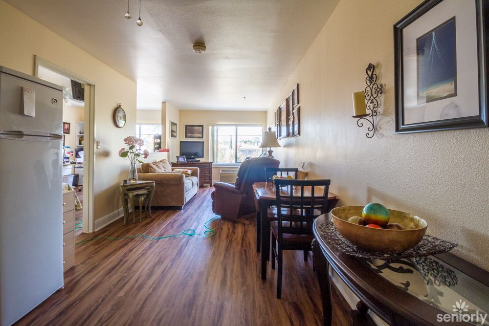 A cozy apartment living and dining area with wood flooring and natural light.