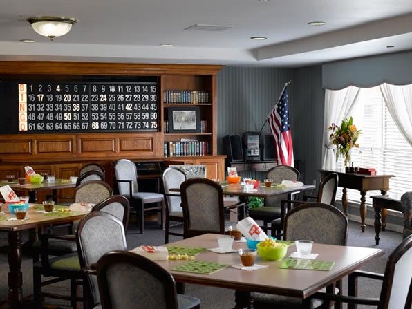 A well-lit dining area with neatly arranged tables and chairs, featuring an American flag and decorative elements.