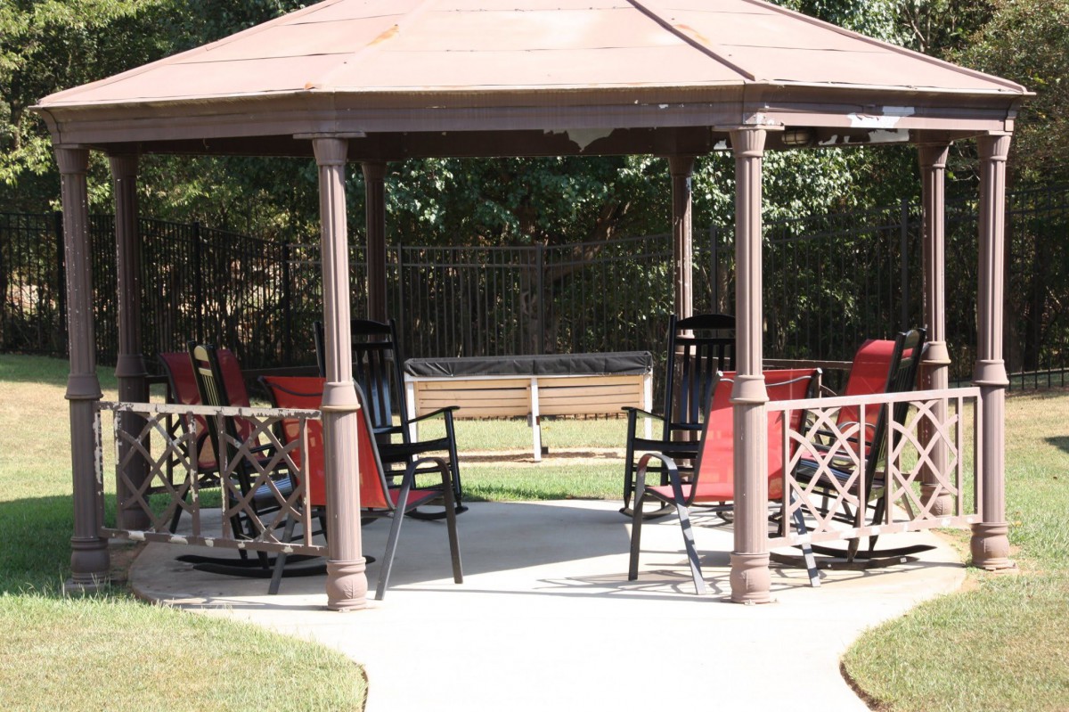 A gazebo with chairs set up in a garden area.