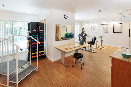 A well-equipped rehabilitation room featuring various exercise tools and equipment for therapeutic purposes.