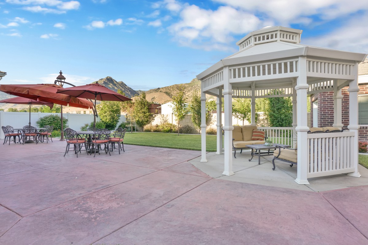 A peaceful backyard patio with a gazebo and outdoor seating.
