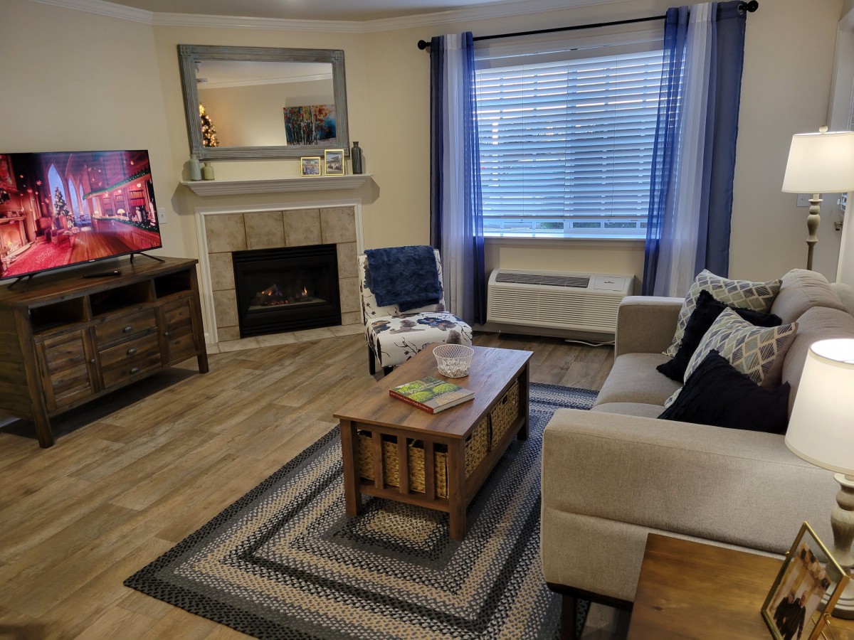 A cozy living room featuring a fireplace, television, and comfortable furniture.