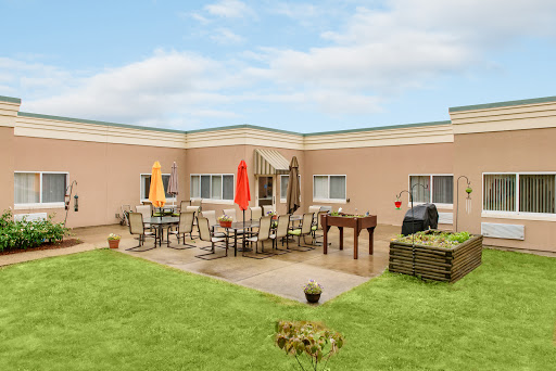 A cozy outdoor patio area with furniture and greenery.
