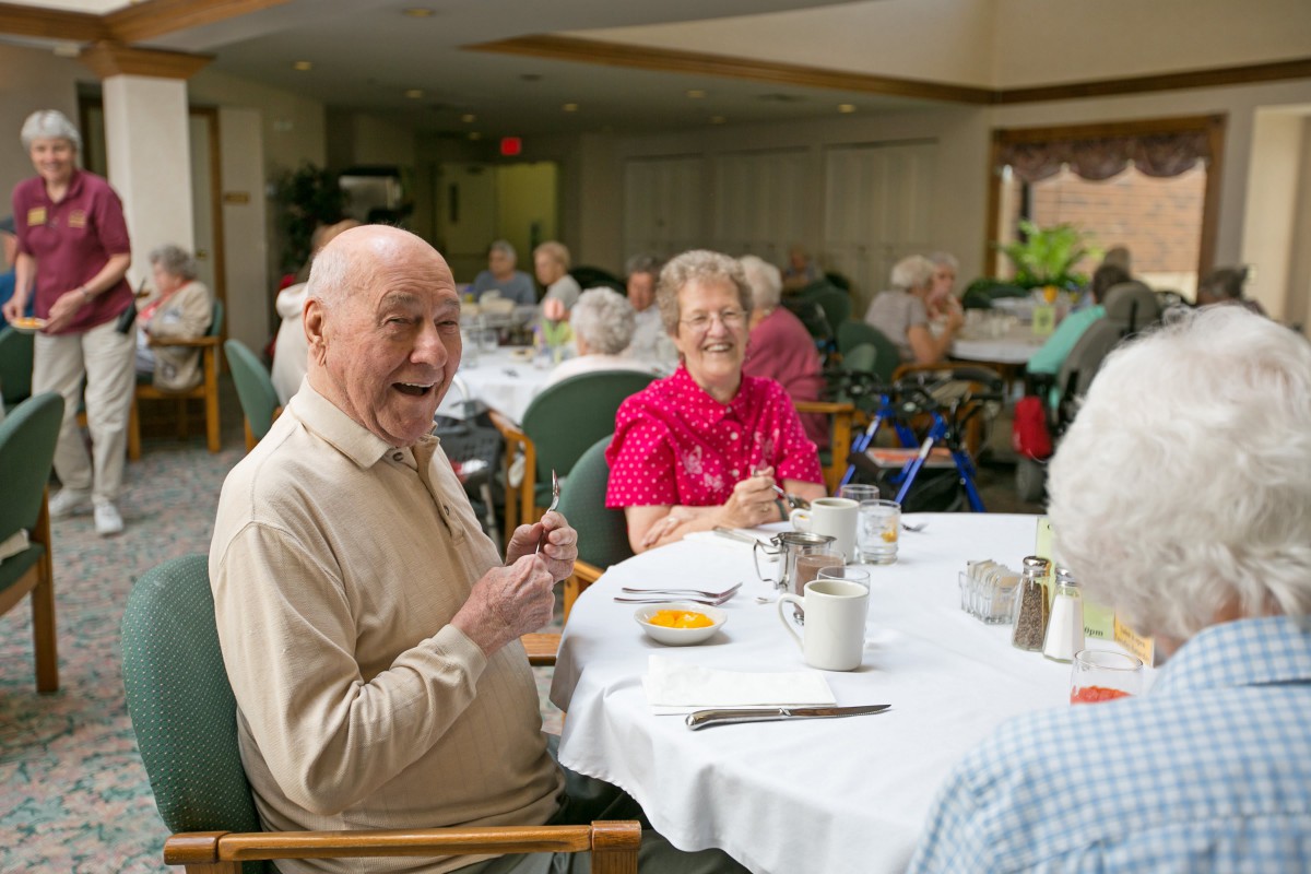Seniors enjoying a meal together in a communal dining area.