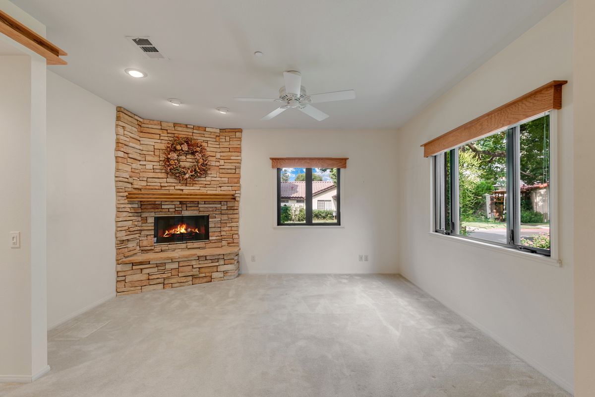 A cozy living room with a brick fireplace and large windows.