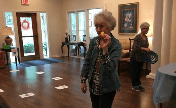 An elderly woman participates in an activity at a community center.