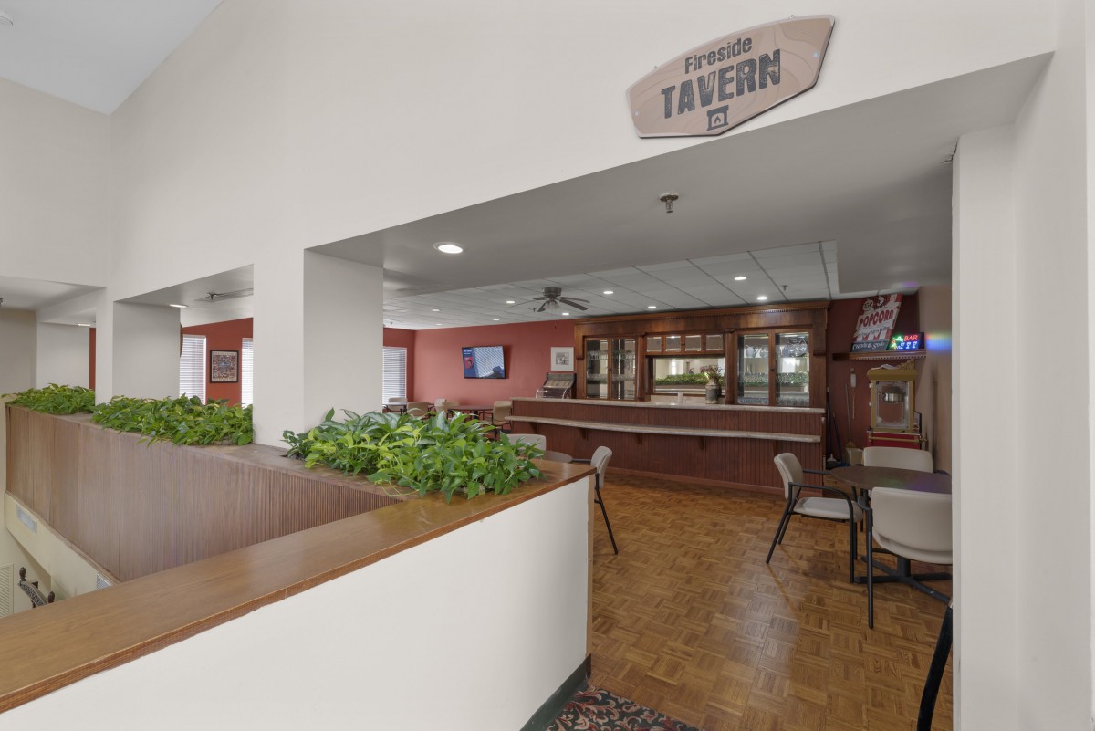 Interior view of a tavern with seating areas and a bar.