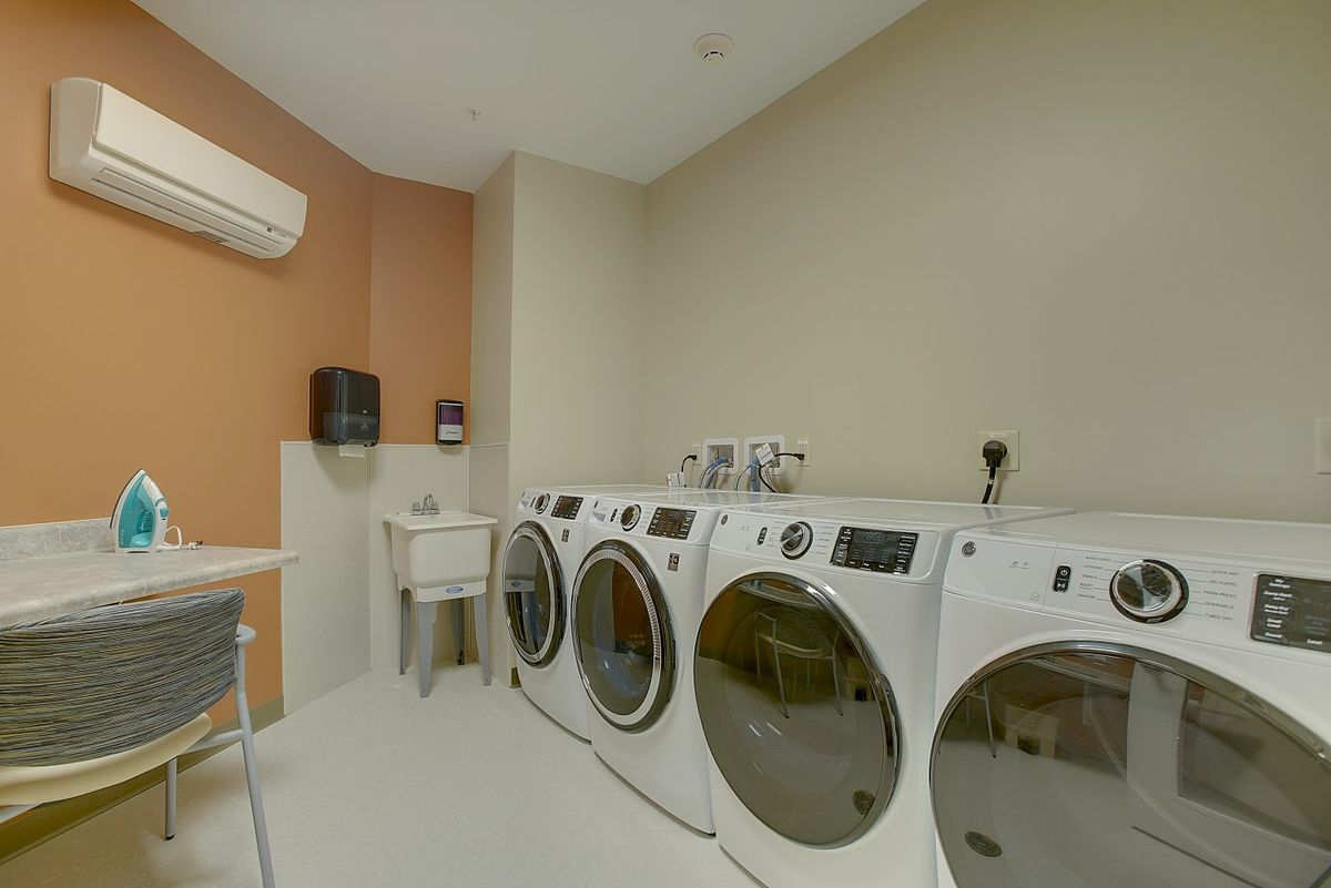 A modern laundry room with multiple washing machines and dryers.