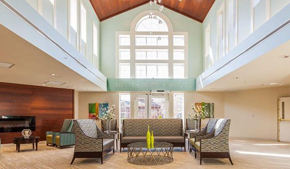 A spacious living room with high ceilings, large windows, and elegant furniture.