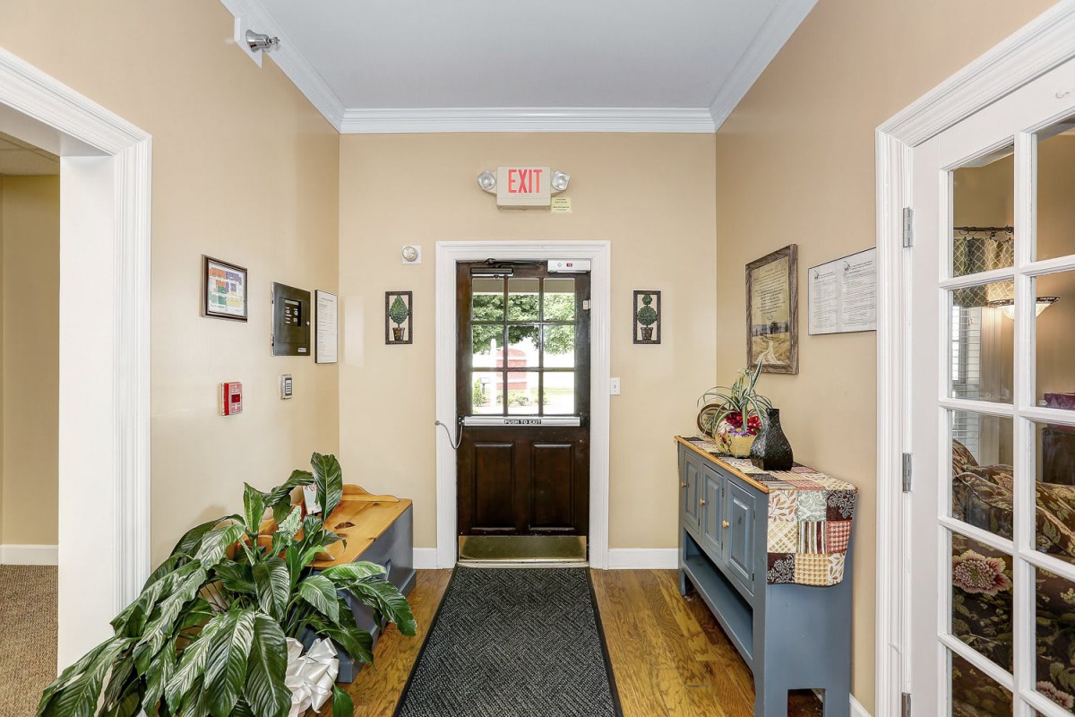 A cozy hallway with wooden flooring and decorative elements including plants and artwork.
