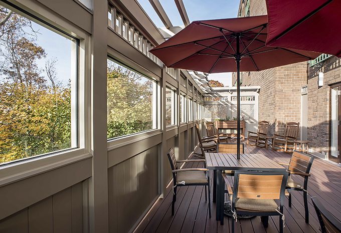 Cozy outdoor patio with tables and umbrellas on a wooden deck.