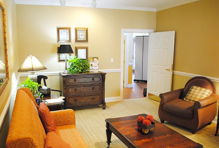 A cozy living room featuring comfortable seating, a wooden coffee table, and decorative elements like plants and artwork.