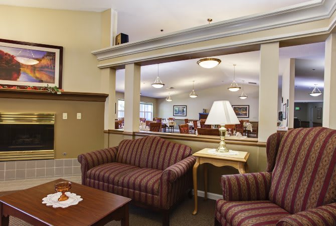 Comfortable seating area in a lobby with sofas, a lamp, and a table.