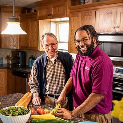 Two people preparing vegetables together in a kitchen.