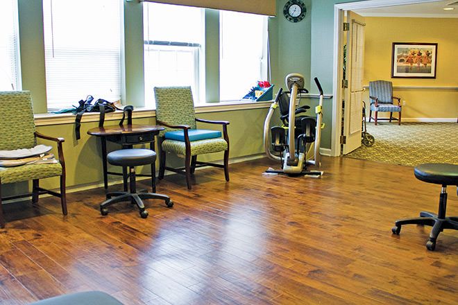 A rehabilitation room with exercise equipment and seating.