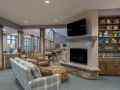 A modern living room featuring a fireplace, large windows, and comfortable seating.
