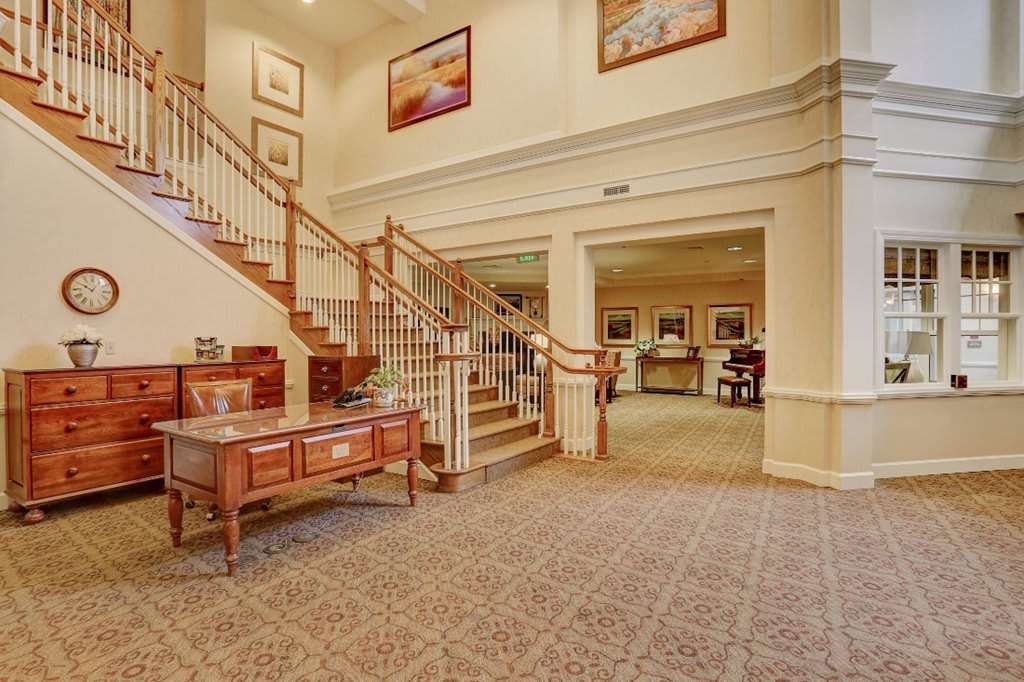 A spacious lobby with a grand staircase and elegant furnishings.