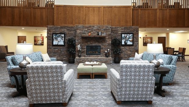 A modern living room with a stone fireplace and comfortable seating area.