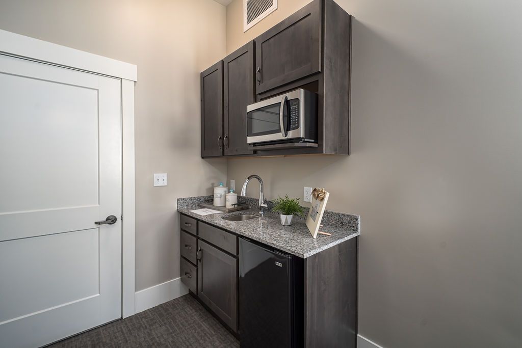 A modern kitchen setup featuring dark cabinets and a microwave.