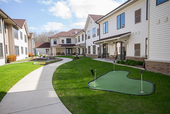 A modern residential building with a well-maintained lawn and a pathway.