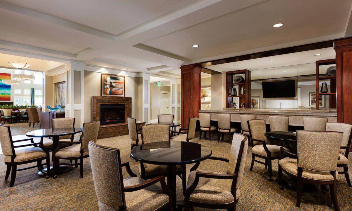 A cozy lounge area with comfortable seating, a fireplace, and a television.
