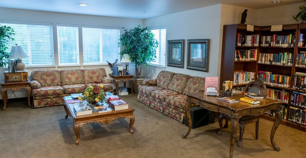 A cozy waiting room with comfortable sofas, a coffee table with magazines, and decorative elements creating a welcoming atmosphere.
